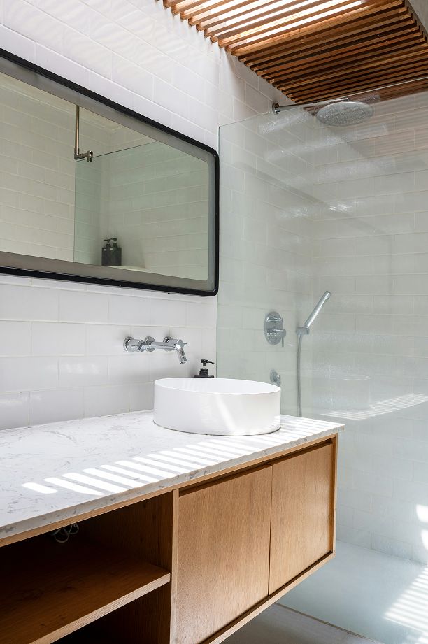 Modernes Badezimmer mit Holzlattendecke, einem weißen runden Waschbecken auf einer Marmorplatte und einer Dusche mit Glaskabine.